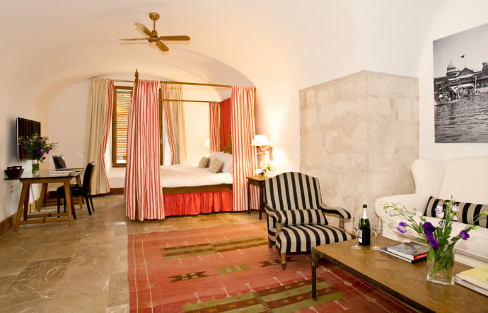 Les suites nuptiales avec lit à baldaquin et tentures à l’esprit médiéval.
