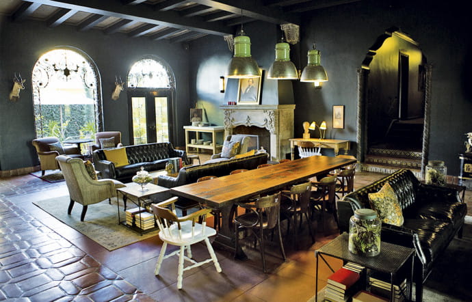 Banquettes de bistro en velours olive, table de retour de chasse, meubles quakers, bergères capitonnées et natures mortes : un vrai melting-pot décoratif.