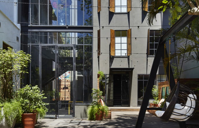 Une façade entre urbain et traditionnel, une cour ensoleillée et verdoyante, du mobilier outdoor au design pointu et le tour est joué : on se sent comme à la maison !