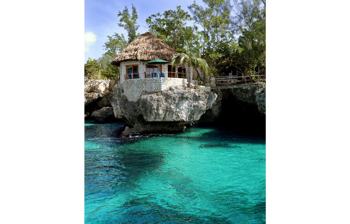 De petites maisons en pierre se fondent dans la côte rocheuse surplombant les eaux turquoises de la mer des caraïbes…