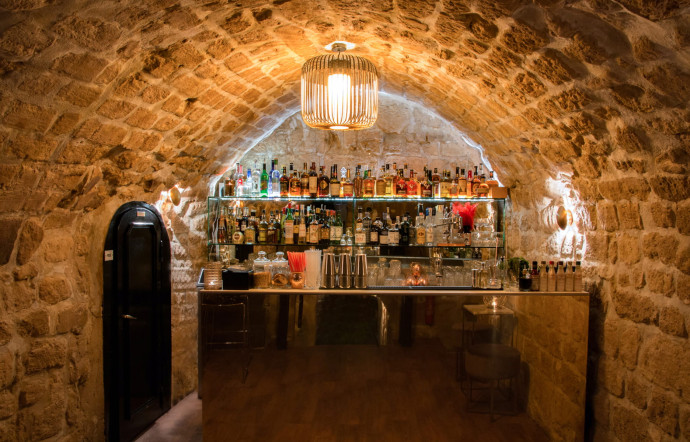 Au sous-sol, le bar à cocktail est installé sous les voûtes de pierre.