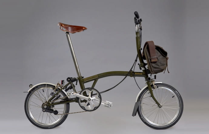 Le « pack » Brompton x Barbour comprend un M6L couleur Barbour Green (guidon classique, 6 vitesses et garde-boues) avec une veste Newham bleue marine et un sac Tarras. 2010 €.