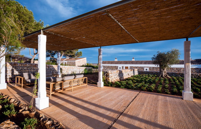 Torralbenc, le premier boutique‑hôtel minorquin, est logé dans une ancienne finca (ferme traditionnelle) entourée de vignes, transformée en retraite paradisiaque.