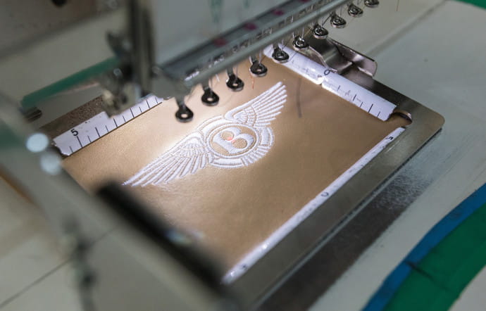 Le logo ailé, brodé sur cuir, est composé de 4 760 points de couture.