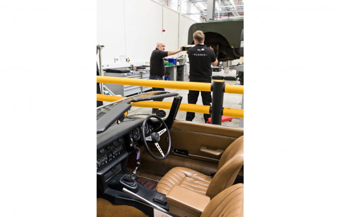 Dans l’immense atelier de Coventry, d’une hauteur sous plafond d’une dizaine de mètres, les techniciens s’affairent sur une cinquantaine de voitures en même temps.