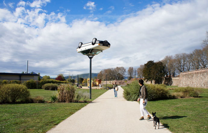 Une Audi 80 blanche surmontant un lampadaire, installation de Benedetto Bufalino