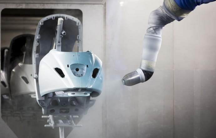 Une fois la coque du scooter préparée, des robots appliquent la couche de peinture primaire, la couche de couleur et, enfin, la couche transparente qui lui donne son brillant.