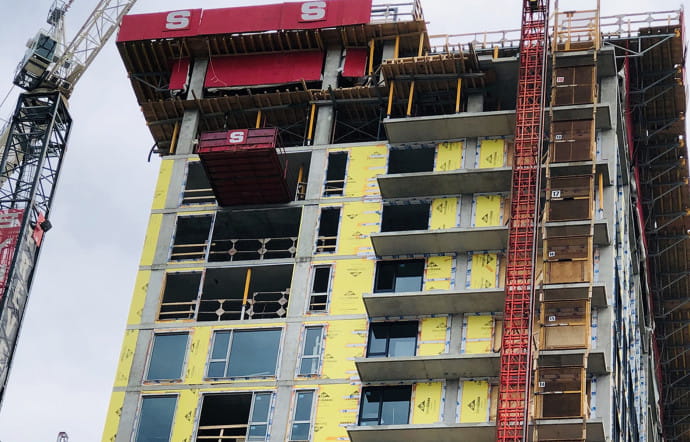 Construction d’un immeuble en plein coeur de Montréal recouvert de film de protection du groupe Chargeurs.