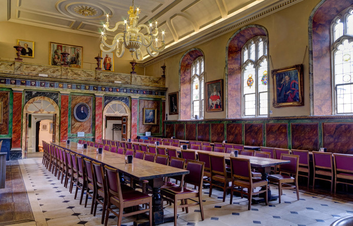 De longues tables en bois, des chaises en velours, un lustre imposant : bienvenue dans la salle à manger du Trinity College.