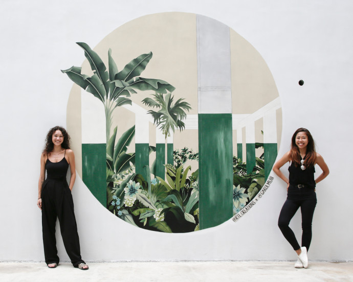 Les artistes Carol Mui et Rebecca T Lin devant leur travail. Emblématique, cette œuvre reprend leur élément signature : la végétation luxuriante. ©Carol Mui et Rebecca T Lin