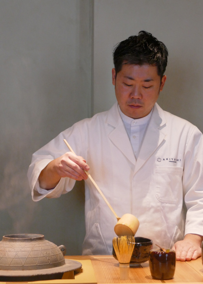Le chef Yuichiro Akiyoshi prélève l’eau chaude dans la bouilloire « kama » avec un « hishaku », longue louche en bambou, et la verse lentement dans un bol.