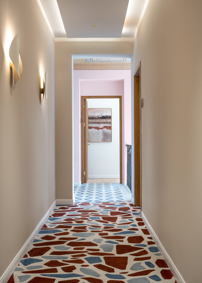 Une moquette au motif graphique qui reprend des fragments de terrazzo couvre les couloirs.