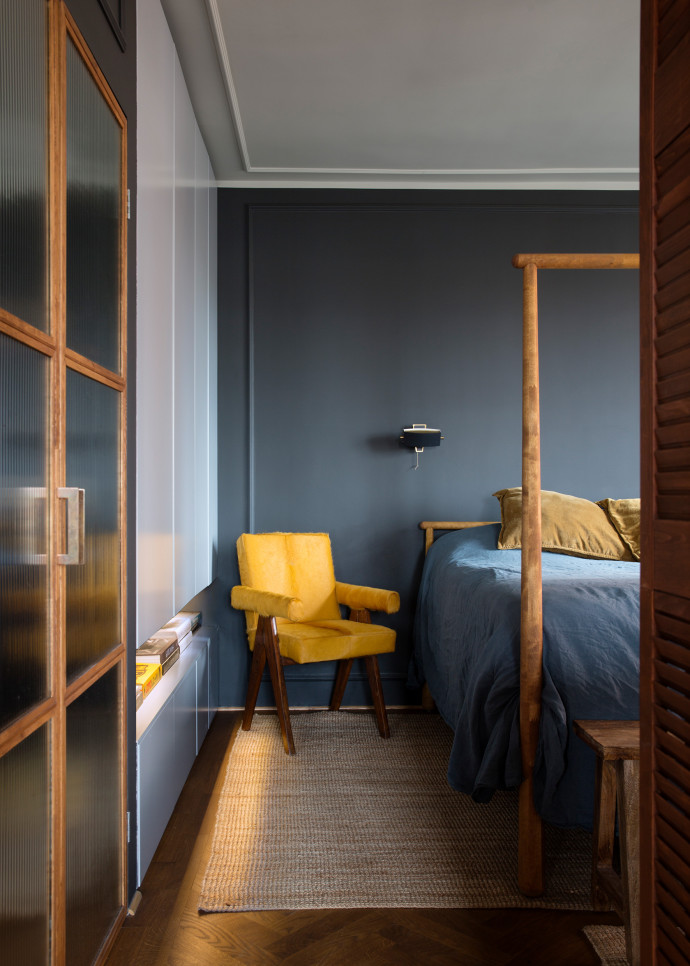 Chambre à coucher : fauteuil d’avocat Pierre Jeanneret en cuir jaune, linge de lit Merci. La porte coulissante donne surune petite salle de bains.