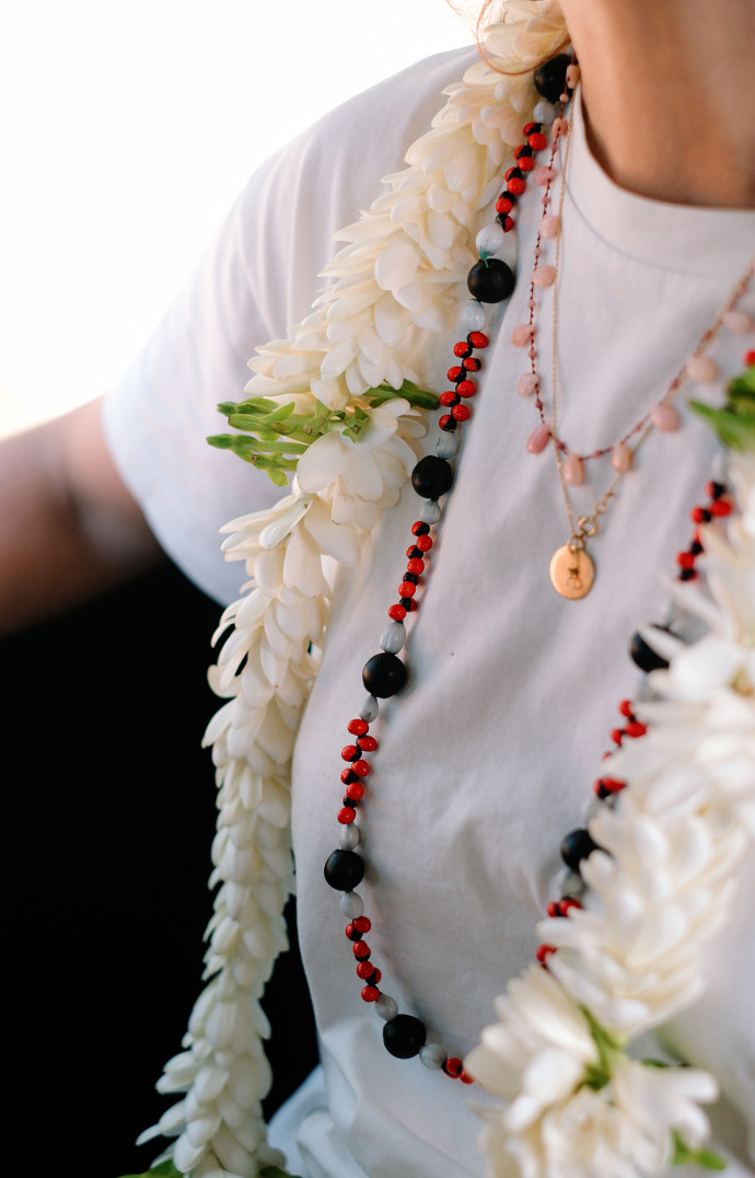 Le collier de fleur signifie la bienvenue sur une île. Le collier noir et rouge, fait de graines locales, s’échangent au moment du départ sur les Îles Marquises.