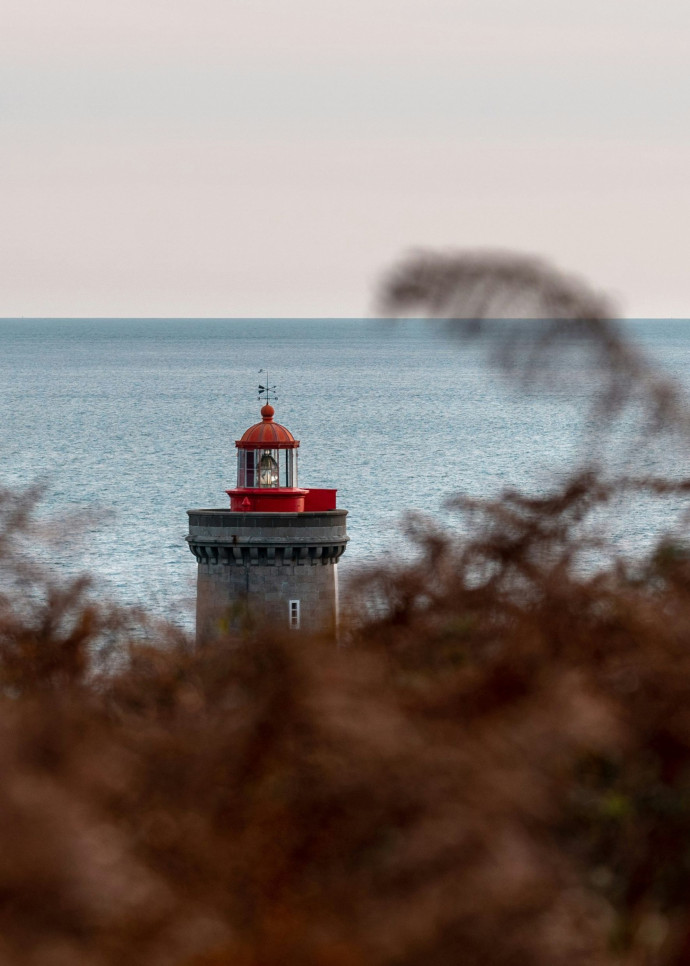 Vue d’un phare sur la plage de Bretagne, entre ciel et mer.