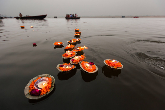 Coupelles en feuilles de bananier remplies de fleurs et de bougies flottant sur le vénérable Gange.