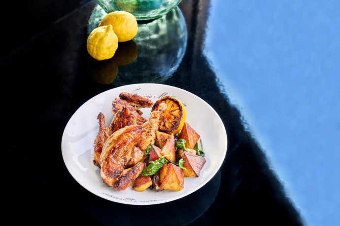Le poulet au confit d’orange, servi avec des pommes de terre, a été mariné toute la nuit dans du lait avec de l’ail et du citron.