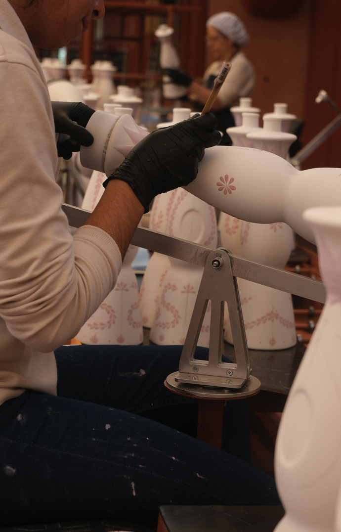 Les artisanes de la marque peignent chaque bouteille à la main.